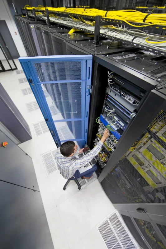 Technician servicing servers in data center rack