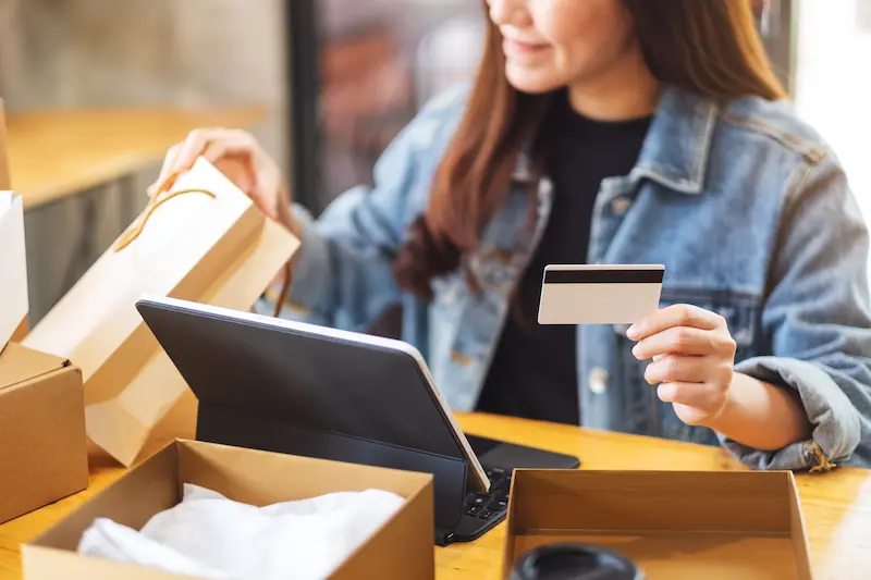 Woman shopping online with credit card and laptop